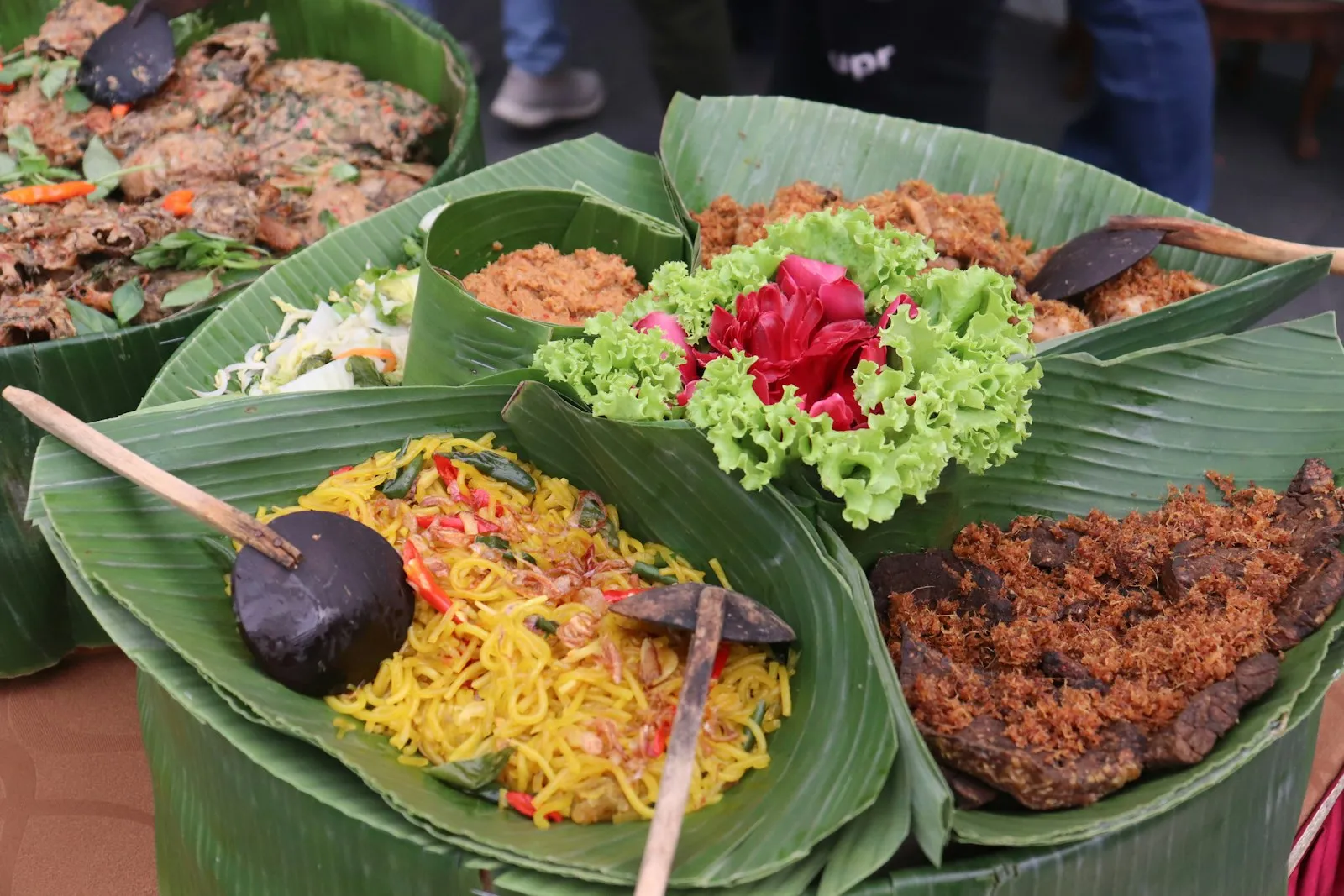 Prasmanan Nusantara dengan nasi, lauk, dan lalapan di atas daun pisang